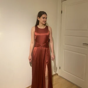 Balklänning - Helt ny balklänning som köptes under corona och därför inte kom till användning. Fin öppning i ryggen och slits. Passar bra på någon med M-L, personen på bilden är 170 och den ligger på marken så perfekt till klackar eller att du jo några centimeter :)