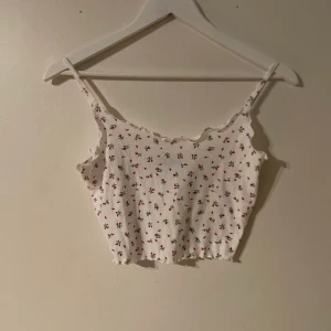 Sommarlinne/croptop med små röda blommor. - Supergulligt linne som inte kommer till användning. Använt max 2 ggr, väldigt fint skick. Fint mönster och modell