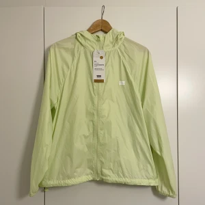 Träningsjacka/Vindjacka från Levi’s strl M - Grön träningsjacka från Levi’s, oanvänd med lappar kvar! Säljes pga kommer ej till användning.  Praktisk ’inbyggd’ magväska, strl M.  Hör av dig vid frågor :)