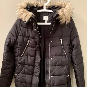 H&M black puffer jacket in excellent condition. Four pockets. Hood with artificial fur. Size 38 