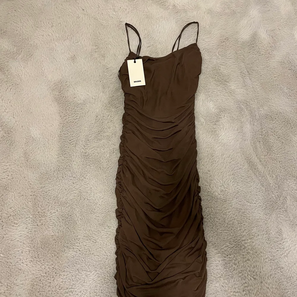 En snygg brun klänning från bikbok som är köpt förra året och helt oanvänd i storlek S. Klänningar.