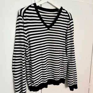 Tunn stickad tröja - Stickad tröja med svart-vit randigt mönster. Köpt second hand. Köparen står för frakt.