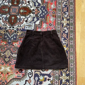 Manchesterkjol brun - A-linjeformad manchesterkjol i mörkbrunt. Köpt second hand. Aldrig använd 