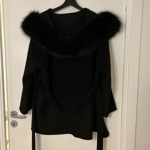 Pälskappa  - Säljer denna kappan eftersom att den inte kommer till användning. Pälsen är äkta och kappan har inga skador. Kappan är en blandning av kashmir och ull.Passar både till vår och höst men även vinter om man har något varmt under. Nypris är 3900.