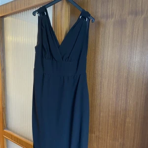 Klänning - V-ringad klänning med spännen och knappar