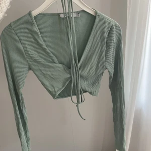 Topp från nakd  - Mintgrön topp från NA-KD med långa ärmar och snören som man knyter i midjan🌸använd en gång ☺️