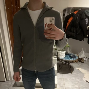 Grå cardigan zip - Grå cardigan zip från Brothers. Väldigt bra skick, inte mycket använd. 