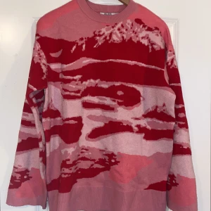 Stickad tröja  - Rosa/röd mönstrad stickad tröja, tyvärr en liten fläck där av billigt pris. 