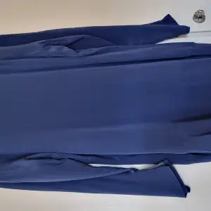 En eleganta klänning från Ana Pires i fin blå färg till cocktailparty eller utekvällen.  I 100% silke och underlinne är i viskos med elastan.