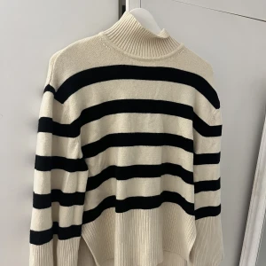 Randig tröja  - En randig tröja, beige och svart, tight polo men väldigt stor och luftig tröja med slits vid höfterna. Från BikBok i storlek XS. Köparen står för frakten. 