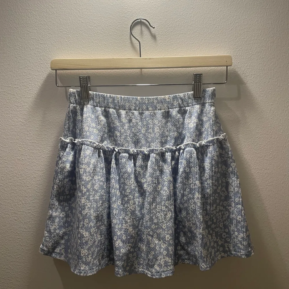 En jättefin ljus blå volang kjol från zara. Den har ett jättefint blommigt mönster. Kjolen har också inbyggda shorts :). Kjolar.