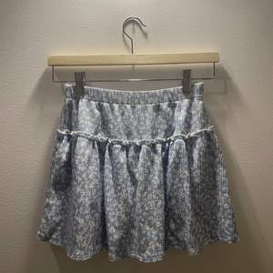 En jättefin ljus blå volang kjol från zara. Den har ett jättefint blommigt mönster. Kjolen har också inbyggda shorts :)