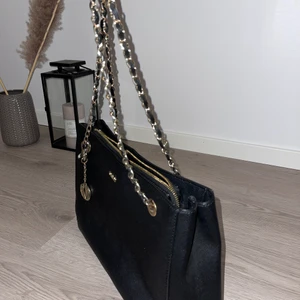 Svart DKNY Väska - Här har ni en riktig snygg väska😍 DKNY väska begagnad, skulle haft kvar den om det inte var FULLT i garderoben🥲 material utanpå: läder. Hoppas ni gillar den🌸