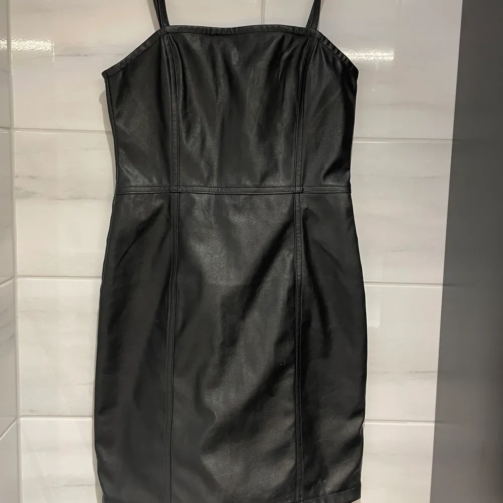 Säljer denna svarta fejkskinn klänning från H&M då den är förliten, den är aldrig använd bara testad och är i storlek 36/XS. Klänningar.