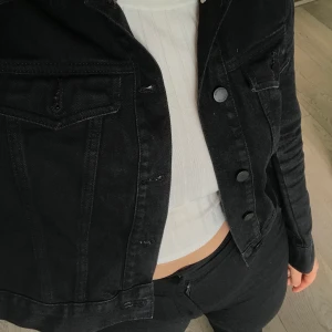 Jeansjacka - Cool jeansjacka med ringar i sidan som går att sätta snöre u om man vill tighta till sidorna. Väldigt bra skick. 