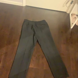 Svarta långa kostymbyxor med en fick bak. - Svarta fina kostymbyxor som var jätte stora för mig med en ficka bak på rumpan. 