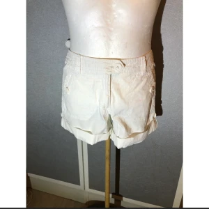 H&M shorts storlek 38 - Vita shorts med fickor fram och bak samt uppvikta ben.