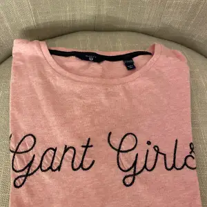 En supersöt Gant Girls T-shirt, rosa med mörkblå text. Är i storlek 158/164 men sitter som en xs/s. Nypris: 400kr, säljer för 75kr. 