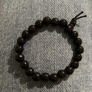 Armband svart  - Svart armband. Finns på Hägerstensåsen i Hägersten 