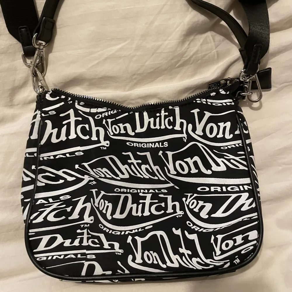 supersöt Von Dutch väska med justerbara remmar och en liten jättesöt pouch-väska på. Väskan är äkta och använd ett fåtal gånger🤍🖤👜. Väskor.