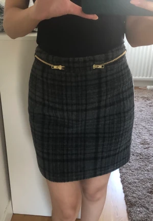 Kjol - Rutig kjol i kort modell med dekorativa dragkedjor framtill. Storlek: 34  Märke: ASOS Använd 1 gång, nyskick 