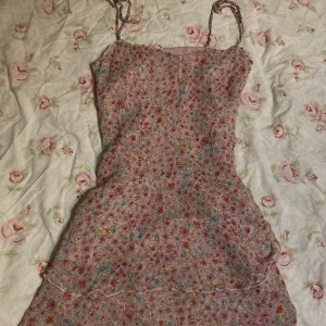 Sommarklänning med blommigt tryck - Supersöt kort klänning med volanger och blommit tryck, man kan även  knyta om axelbanden!💐