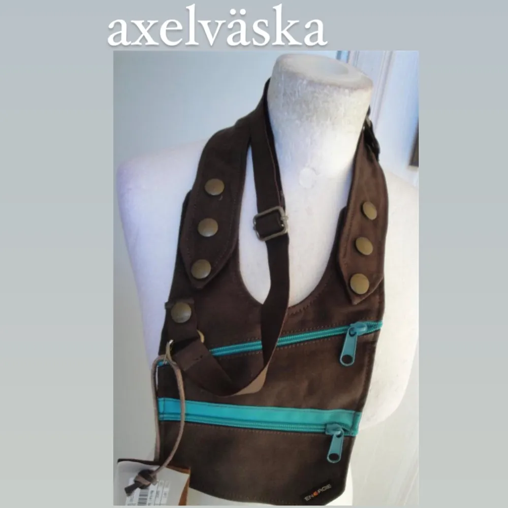Oanvänd/ ny. Köptes på 90-talet. Går även att bära som midjeväska. Möts i stockholm eller fraktar. Mått: 19x17cm Handtagshöjd 23cm . Väskor.