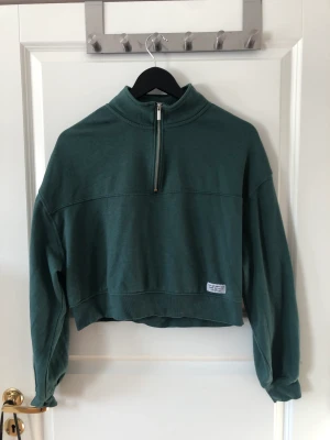 Cropped sweatshirt  - Grön croppad sweatshirt med dragkedja vid halsen, Använd ett fåtal gånger och i bra skick!  Köparen står för frakten