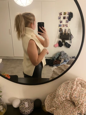 Stickad tröja - Stickad tröja utan armar, i krämvit färg. Säljer då jag har en annan, aldrig använd. Om man vill kan man nog sätta säkerhetsnål så sidorna inte är helt öppna. 