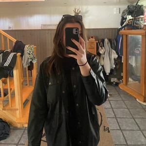 Skinnjacka - Jättefin längre fejk-skinnjacka med knappar och snygga detaljer i svart. Sparsamt använd och väldigt fint skick!  Köpare står för frakt. Hör av dig vid intresse eller för fler bilder🤎