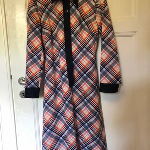 70-talsklänning - Vintage klänning från 70-talet. Klänningen går ner till knäna och har ett blått skärp. 