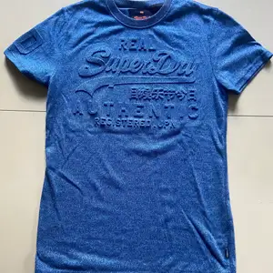 Hej! Säljer denna blåa Superdry Emboss T-Shirten. Knappt använd. Storleken är S och sitter väldigt bra. Nypris: 399k, Mitt pris: 170kr. Köparen står för frakt, kan även mötas upp för att lämna över plagget👍