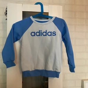 adidas barn kläder  - Blå tröja för barn, med gråa byxor.
