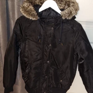 Dunjacka  - Säljer min fina dunjacka från levi’s. Köpt secondhand och är i jättebra skick. Glansigt material med super fin päls runt luvan. Slutar precis ovanför rumpan på mig.