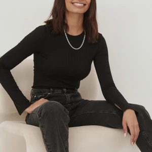 Ribbad topp med slits i ärmarna - Ribbad topp med slits i ärmarna från NA-KD, använd få gånger, säljes då den inte kommer till användning. Storlek XXS men passar även XS