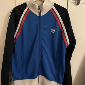 Sergio Tacchini jacka - Sergio Tacchini jacka blå/röd/vit storlek M. Ganska använd men inga täcken på att den använts mycket. Pris kan diskuteras för en overall bra jacka. Köptes för 500kr. Fler bilder finns till den som är intresserad😆