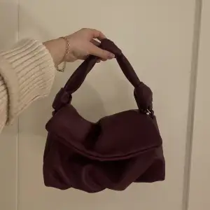 Skitsnygg väska från ginatricot i en lila burgundy färg!! Rymlig och perfekt!!!