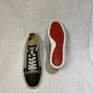 Christian Louboutin  - Christian Louboutin | Junior Spikes Flat Calf/ Granariso  -ALLT OG -Extra nitar, extra snören -Vit/Svarta -Alla nitar kvar -Kondition: 9,5/10 -Storlek: 41,5 (passar större) -Retail pris 8700 SEK -Pris 3799 SEK  Tveka inte på att kontakta oss, 