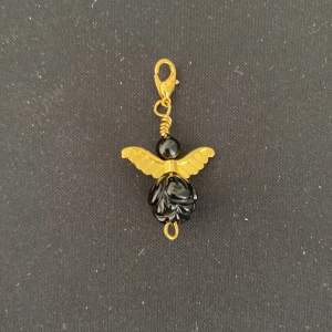 Ett gulligt Halsbandshänge i form av en ängel. Guldetaljer och gjord av onyx, en sten för framgång 💕 helt nytt skick och utan skador 🫶