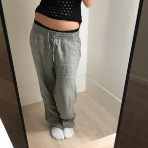 Gröna linnebyxor - Gröna linnebyxor med slits längst ned. Byxorna är i bra skick. Innerbenslängden är 75 cm. Frakt tillkommer på 66kr, kontakta mig gärna vid frågor💕