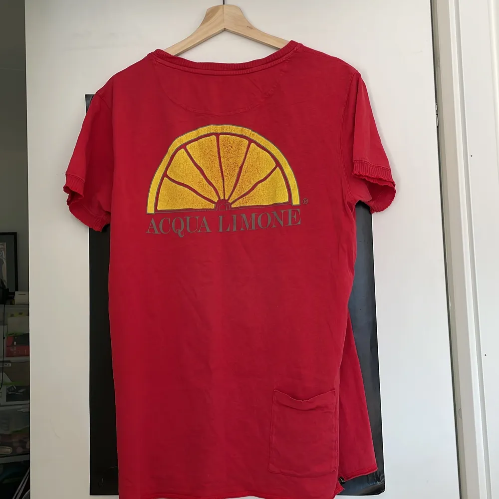 Röd Acqua Limone t-shirt i storlek L. Spår av användning på tryck samt ett litet hål nertill på framsidan, annars hel och fin!. T-shirts.
