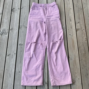Lila jeans - Jeansen är lila och kommer från H&M divided. Byxorna är alldeles förstora på mig därför kommer de inte till användning! De är as snygga och har hål på båda knäna. Köparen står för frakten!