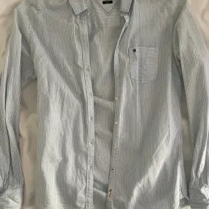 Skjorta i ljusblå/vit från Tommy Hilfiger, modell fitted.