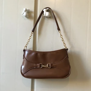 Brun handväska  - Brun väska från Asos design. Aldrig använd. Skickas mot frakt eller mötas i Malmö 