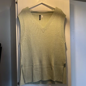 Stickad väst - Stickad väst lite längre i modellen, aldrig använd