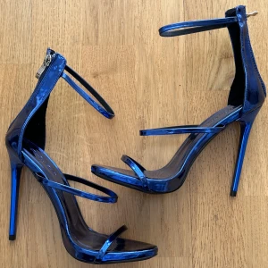 Metallic blue heels  - Klackskor från Rebecca Stellas märke i färgen metallic blue, med tre band. Aldrig använda.  Storlek: har i både 38 & 39. Pris: 100kr