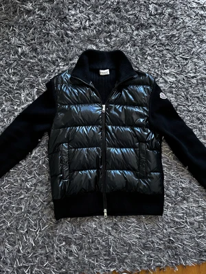Moncler cardigan - Jag säljer min Moncler cardigan i storlek S. Den är lite stor i storleken så den passar M. Den är knappt använd och kvitto medföljer.  Nypris är drygt 8800kr, kontakta för fler bilder och svarar gärna på frågor kring plagget.