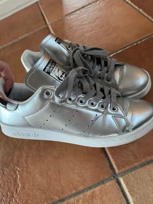 Silver metallic Stan Smith - Skiitsnygga silvriga Stan Smith som tyvärr är för små för mig:( Använt men fint skick och tvättade nyss utsidan och sulan på dem! Nypris 1000kr🫶🏼🫶🏼 Storlek 39,5! 