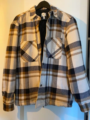 Jacka/overshirt - Jacka från hm som passar perfekt till hösten. Sparsamt använd! En knapp är bytt på ena ärmen, men det är inget som påverkar funktionen. Den är lite oversized så passar S/M