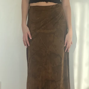 Jättefin brun kjol med coolt mönster - Superfin brun kjol från Dolores med ascool tryck köpt secondhand. Waist: 70cm Längd: 86cm